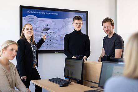 Foto: Studierende der accadis Hochschule erklären ein Schaubild