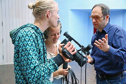 Foto: Dozent und Studierende bereiten Filmaufnahmen vor