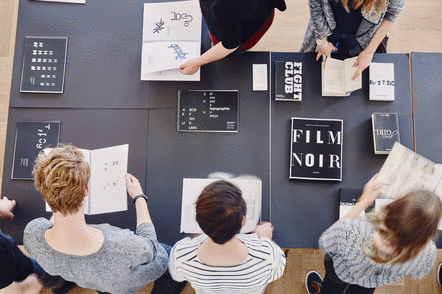 Foto: Studierende sichten Bücher und Schriftarten 