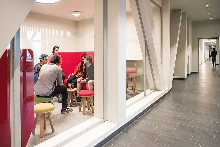 Foto: Studierende der ESMT European School of Management and Technology sitzen in einem Aufenthaltsraum und unterhalten sich.