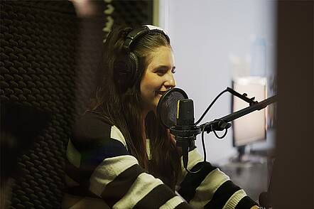 Foto: Eine Studentin macht eine Aufnahme im Tonstudio der Media University