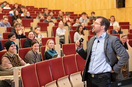 Foto: Lehrende und Studierende tauschen sich während eines Seminars fachlich aus.