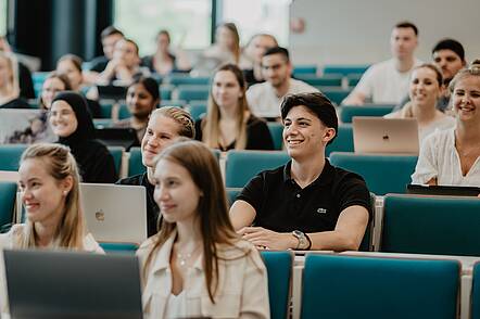 Foto: Studierende sitzen während einer Lehrveranstaltung im Hörsaal. 