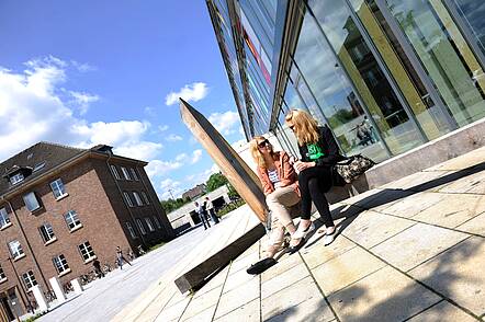 Foto: Studierende sitzen auf dem Campus der Technischen Hochschule Ostwestfalen-Lippe und unterhalten sich