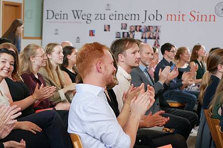 Foto: Studenten applaudieren in einem Hörsaal der Evangelischen Hochschule Tabor.