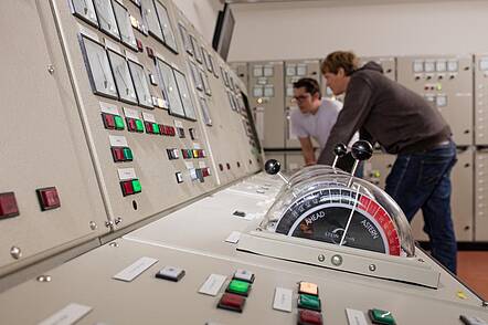 Foto: Studierende kontrollieren das Steuerungspult. 