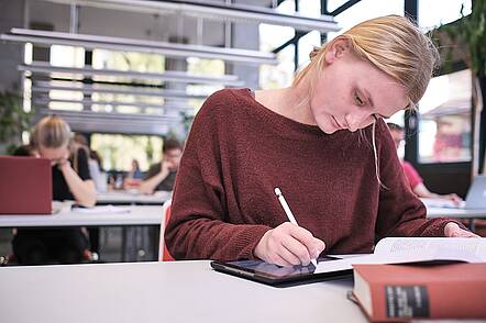 Foto: Studentin arbeitet in der Bibliothek der Hochschule für Philosophie. 