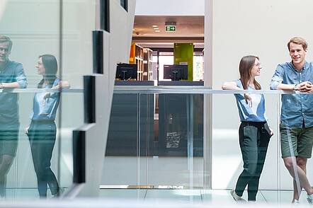 Foto: Zwei Studierende der Universität Heidelberg stehen an einer Treppe.