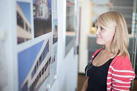 Foto: Studierende betrachtet Fotos auf einem Whiteboard