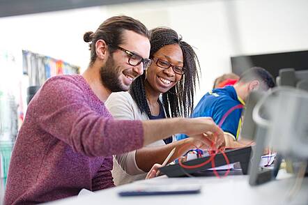 Foto: Zwei Studierende an einem Tisch mit einer technischen Anwendung