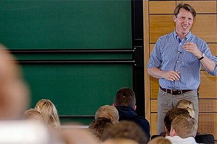 Foto: Lehrender diskutiert mit Studierender während der Vorlesung.