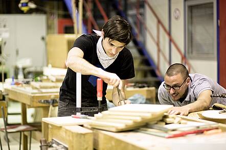 Image: Two students work with wood in the wood workshop of the Faculty of Art and Design.