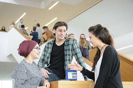 Image: Students talking in the central lecture hall building 