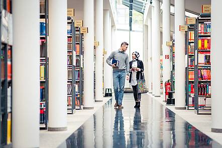 Foto: Studierende recherchieren in der Bibliothek 