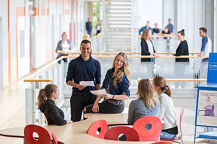 Foto: Studierende sitzen zusammen und unterhalten sich.